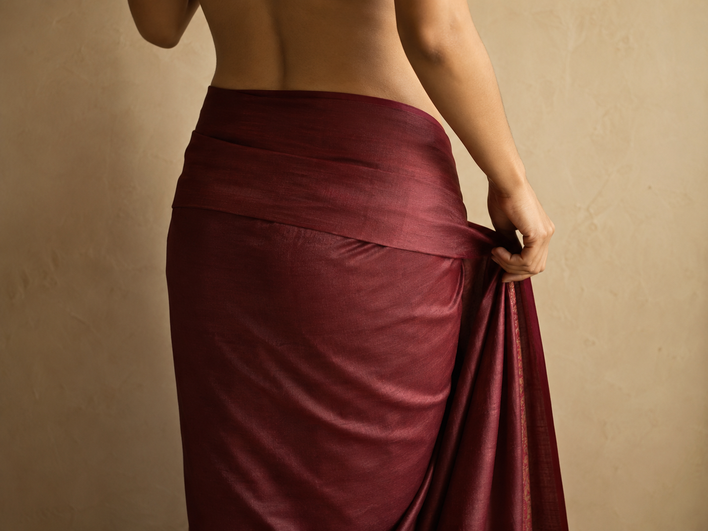 A saree wrapped once around the body from the right hip, fabric falling smoothly to the floor