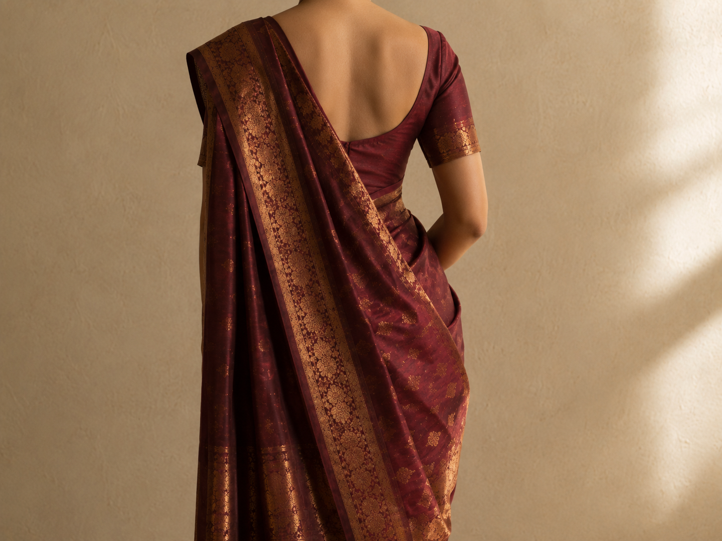 The pallu of a saree draped over the left shoulder falling smoothly down the back to knee length