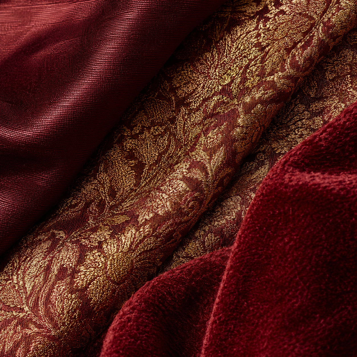 Macro detail of three saree blouse fabrics — pure silk, gold-zari brocade, and deep red velvet