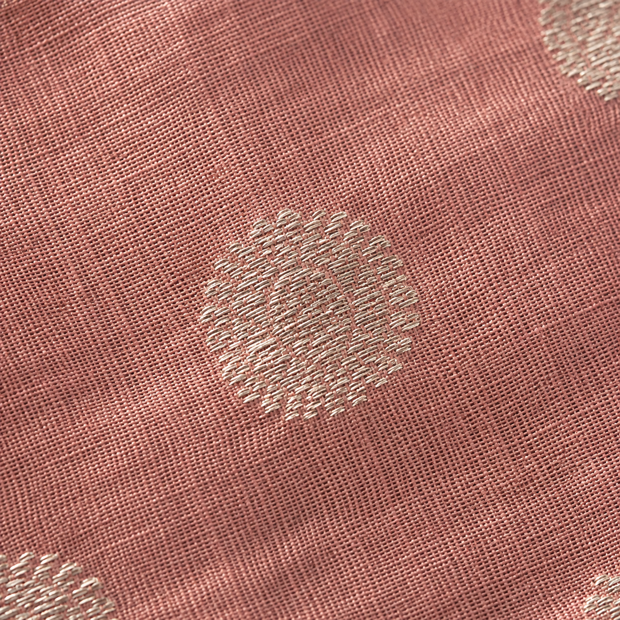 Close detail of the signature Chanderi buta motif — small silver zari coin pattern woven into translucent silk-cotton fabric